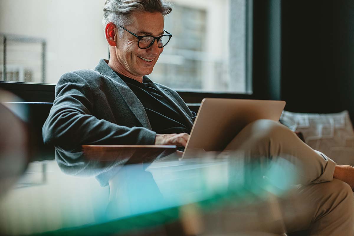 Business owner smiling while reviewing business documents, showing satisfaction in selling a small business