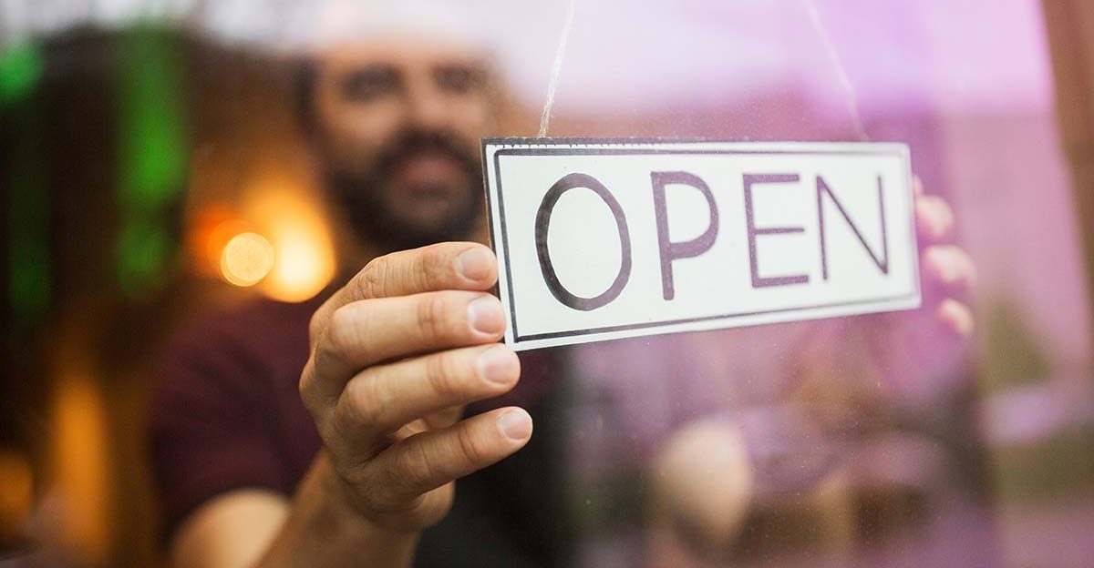 Business owner opening their store, representing starting a business journey as part of the selling a business checklist.