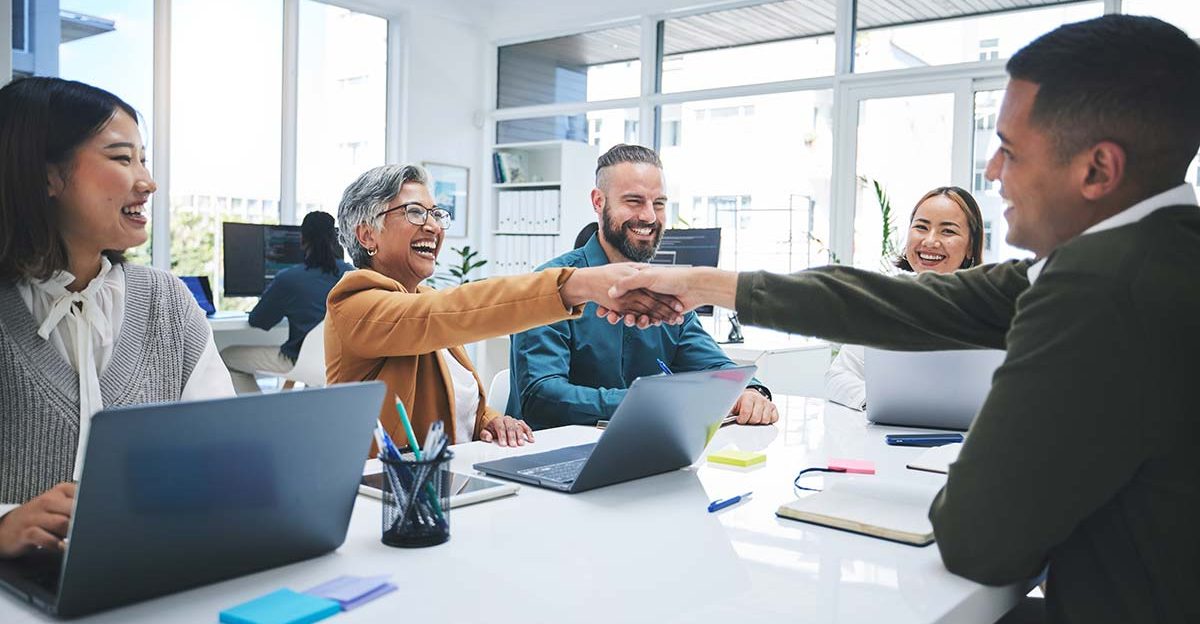 Group of professionals shaking hands after a meeting, sealing the deal to buy an existing business.